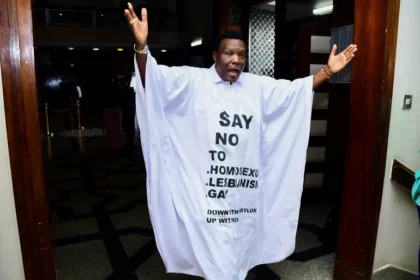 Ugandan member of parliament John Musira dressed in an antigay gown during debate of the Anti-Homosexuality bill in Kampala, Uganda, on March 21, 2023 [Abubaker Lubowa/Reuters]