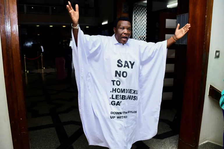 Ugandan member of parliament John Musira dressed in an antigay gown during debate of the Anti-Homosexuality bill in Kampala, Uganda, on March 21, 2023 [Abubaker Lubowa/Reuters]